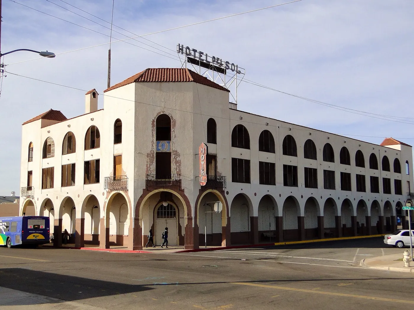 Historic Hotel del Sol in downtown Yuma, Arizona, showing its three-story Spanish Revival facade, arched walkways, red tile roof and rooftop sign.